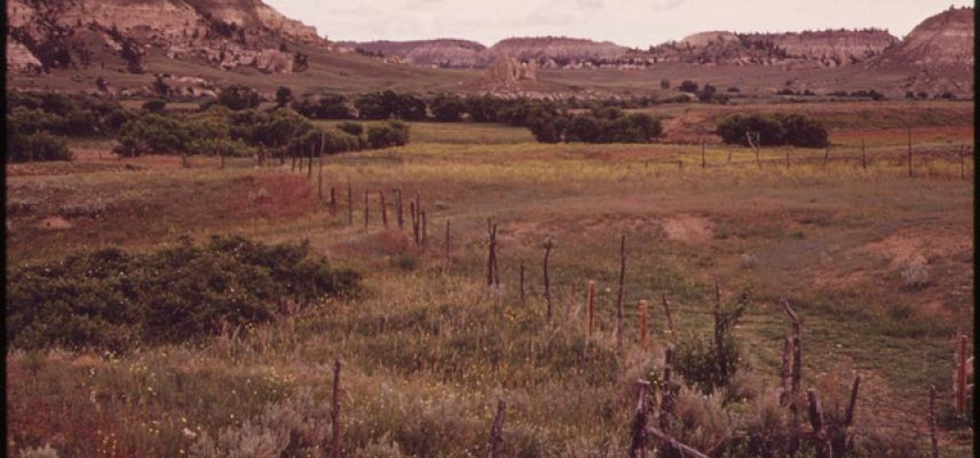 Montana ranchlands with fence, scrub and hills